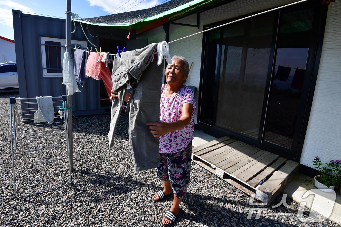 (영덕=뉴스1) 최창호 기자 = 16일 경북 영덕 산불 피해지역인 뇌물리 주민인 70대 서 모씨가 임시주택에서 빨래를 햇볕에 말리고 있다.영덕 산불은 올 3월 22일 경북 의성군에 …