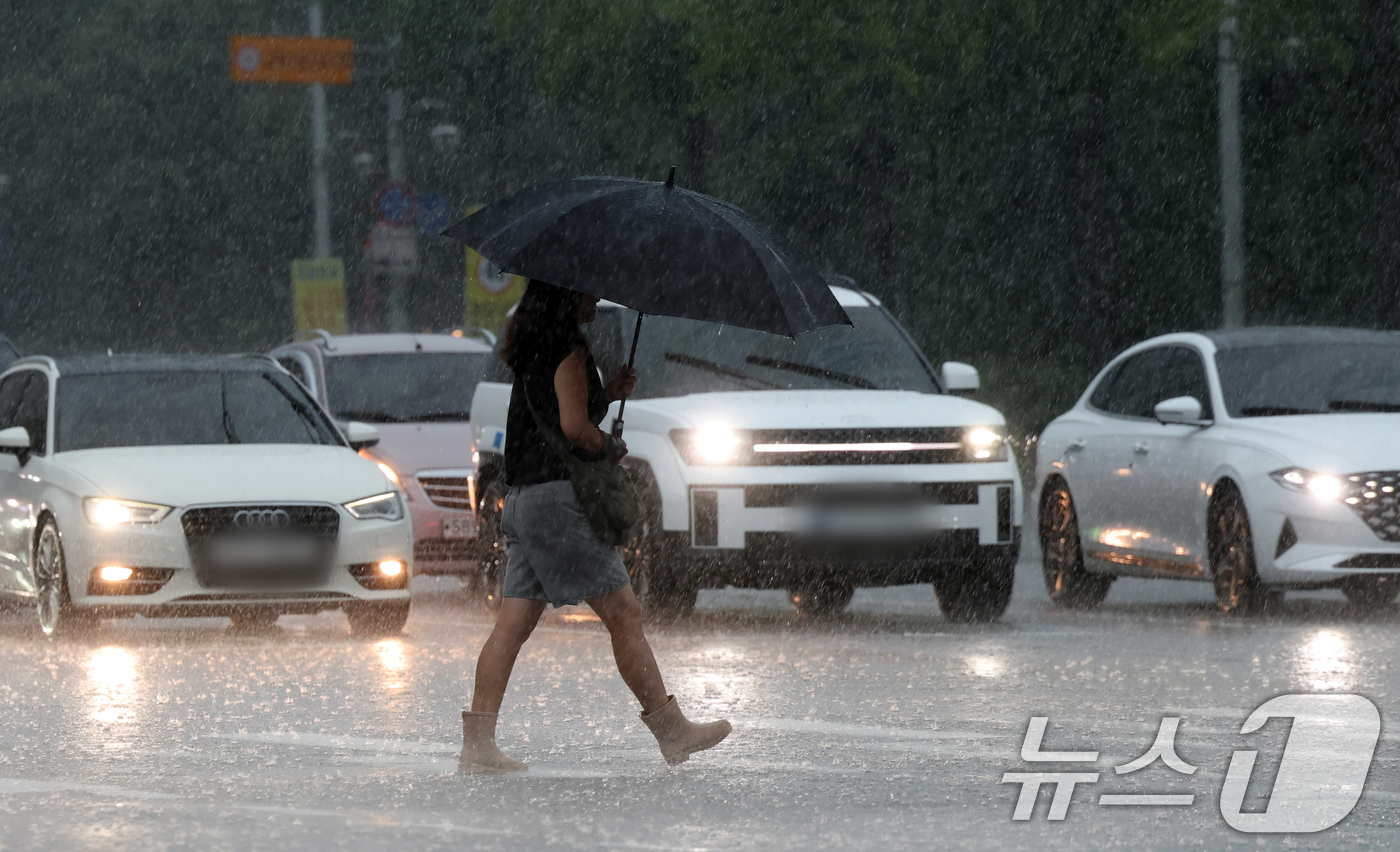 (수원=뉴스1) 김영운 기자 = 수도권 곳곳에 호우주의보가 내려진 16일 오후 경기 수원시 영통구의 한 도로에서 시민이 우산을 쓰고 걸어가고 있다. 2025.9.16/뉴스1