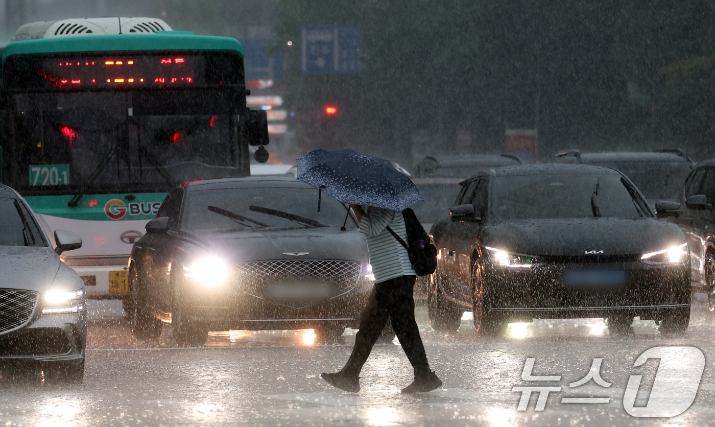 (수원=뉴스1) 김영운 기자 = 수도권 곳곳에 호우주의보가 내려진 16일 오후 경기 수원시 영통구의 한 도로에서 시민이 우산을 쓰고 걸어가고 있다. 2025.9.16/뉴스1