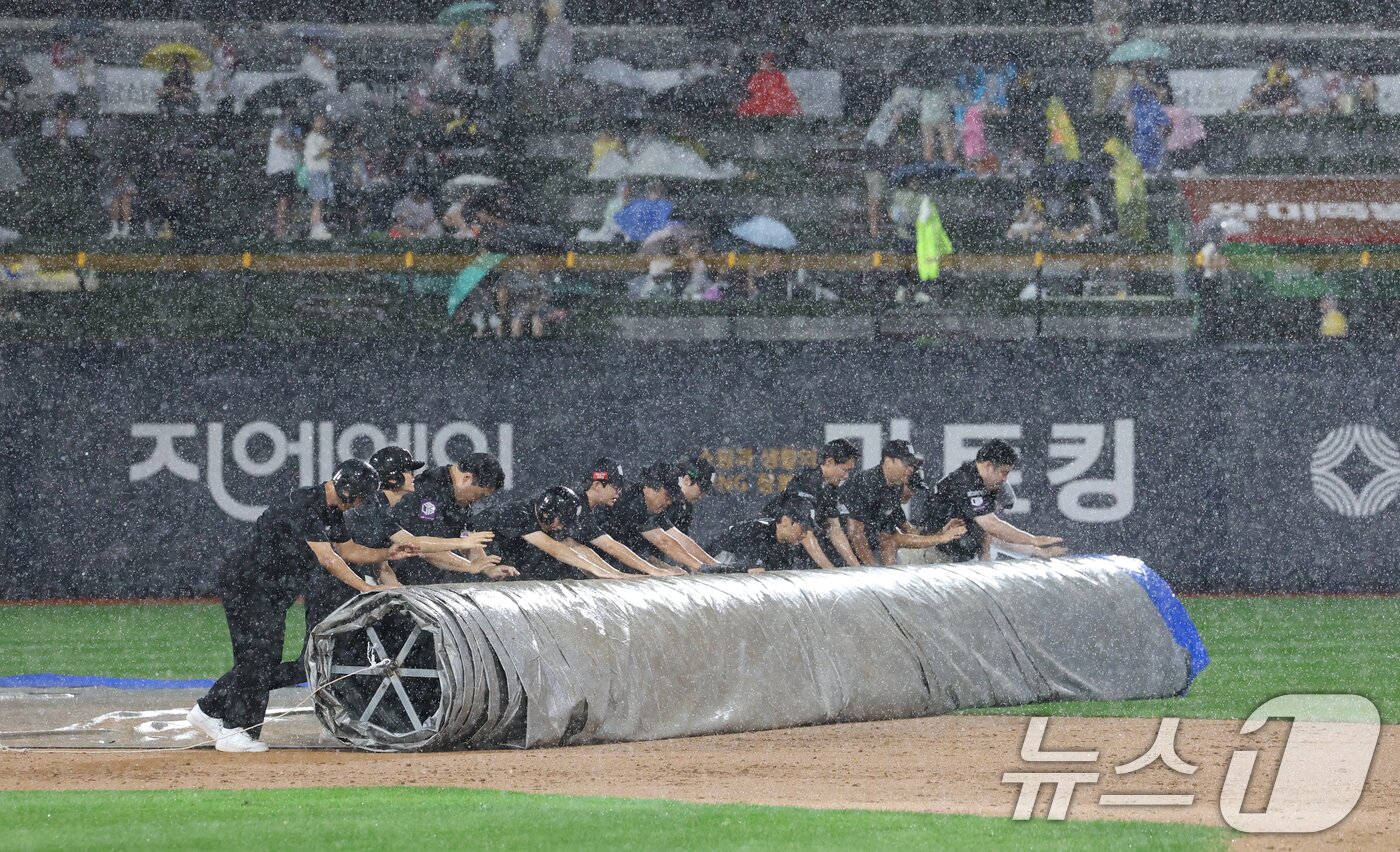 본문 이미지 - 16일 오후 경기 수원시 장안구 KT위즈파크에서 열린 '2025 신한 SOL 뱅크 KBO리그' LG 트윈스와 KT 위즈의 경기, 3회말 우천으로 경기가 중단돼 구단 관계자가 방수포를 덮고 있다. 2025.9.16/뉴스1 ⓒ News1 김영운 기자