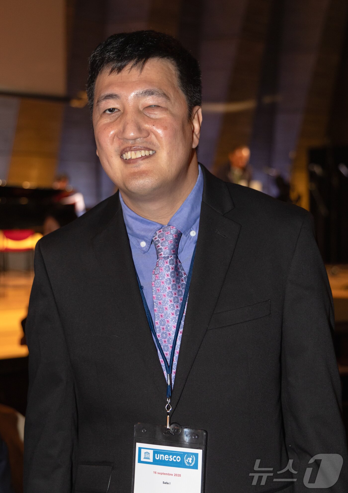 본문 이미지 - 16일&#40;현지시간&#41; 프랑스 파리 유네스코 본부 본회의장에서 열린 국제 시각장애인 음악축제에서 편곡자로 참여한 김치국 미국 버클리 음대 교수가 인터뷰 사진 촬영을 하고 있다. 2025.9.17/뉴스1 ⓒ News1 이준성 기자