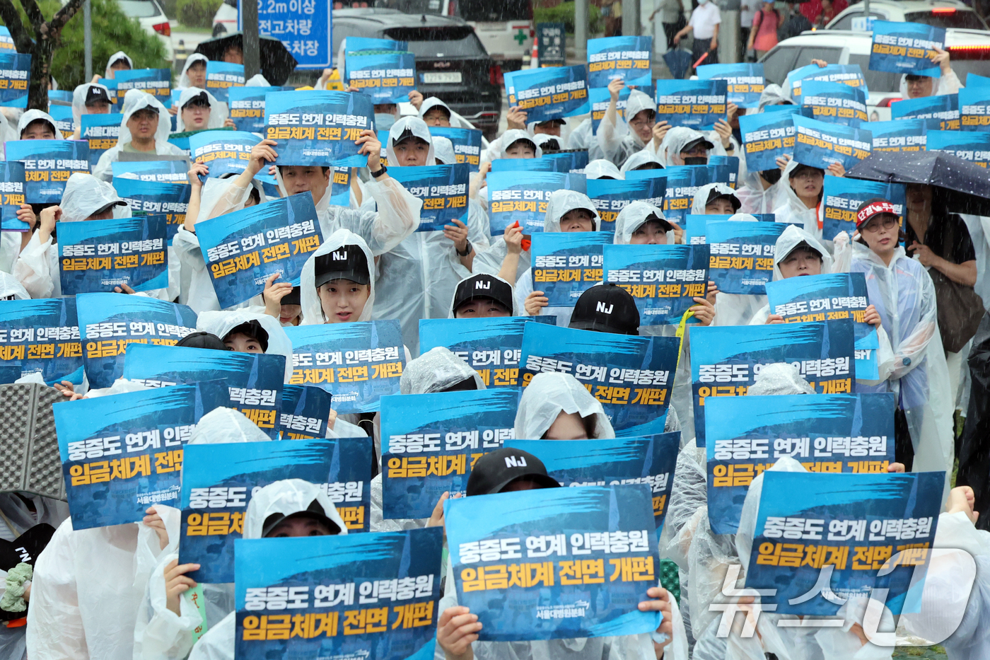 (서울=뉴스1) 황기선 기자 = 공공운수노조 의료연대 서울대병원분회 조합원들이 17일 오전 서울 종로구 서울대병원 본관 시계탑 앞에서 열린 '공동파업 출정식'에서 구호를 외치고 있 …