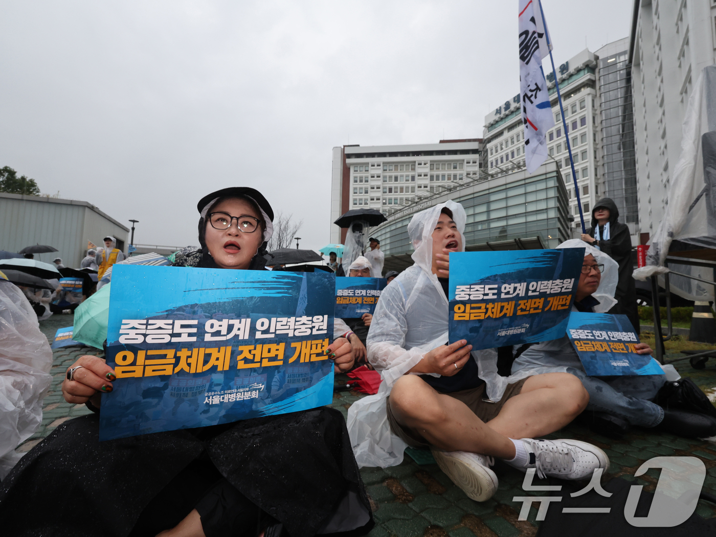 (서울=뉴스1) 황기선 기자 = 공공운수노조 의료연대 서울대병원분회 조합원들이 17일 오전 서울 종로구 서울대병원 본관 시계탑 앞에서 열린 '공동파업 출정식'에서 구호를 외치고 있 …