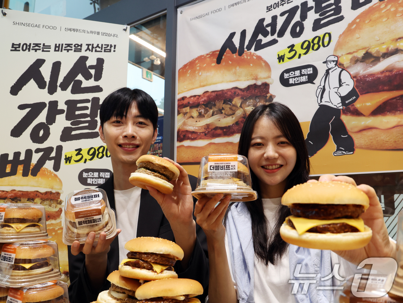 (서울=뉴스1) 황기선 기자 = 17일 서울 성동구 이마트24 성수동 본사에서 모델들이 프리미엄버거 2종을 소개하고 있다.이마트24가 신세계푸드와 손을 잡고 만든 '더블비프치즈버거 …