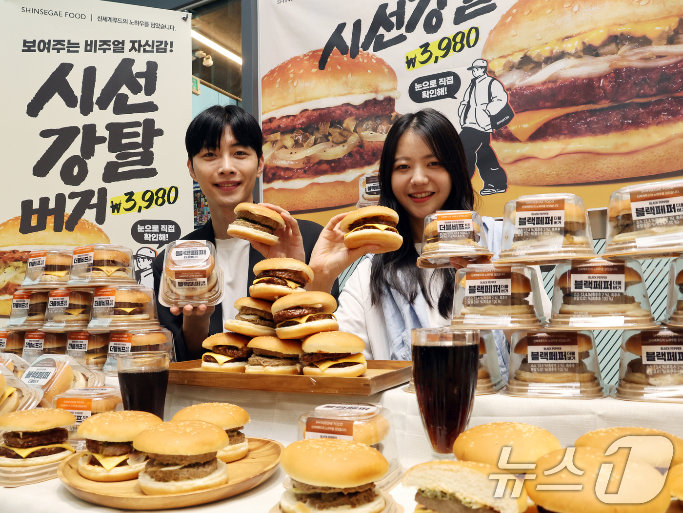(서울=뉴스1) 황기선 기자 = 17일 서울 성동구 이마트24 성수동 본사에서 모델들이 프리미엄버거 2종을 소개하고 있다.이마트24가 신세계푸드와 손을 잡고 만든 '더블비프치즈버거 …