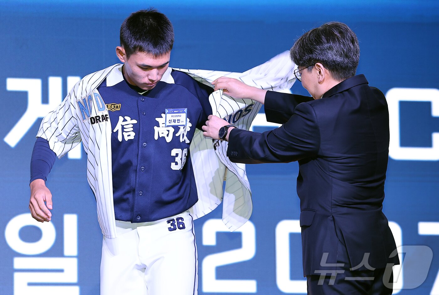 본문 이미지 - 17일 오후 서울 송파구 롯데호텔 월드에서 열린 ‘2026 KBO 신인 드래프트’에서 1라운드 2순위로 NC 다이노스에 선발된 신재인이 유니폼을 입고 있다. 2025.9.17/뉴스1 ⓒ News1 김진환 기자