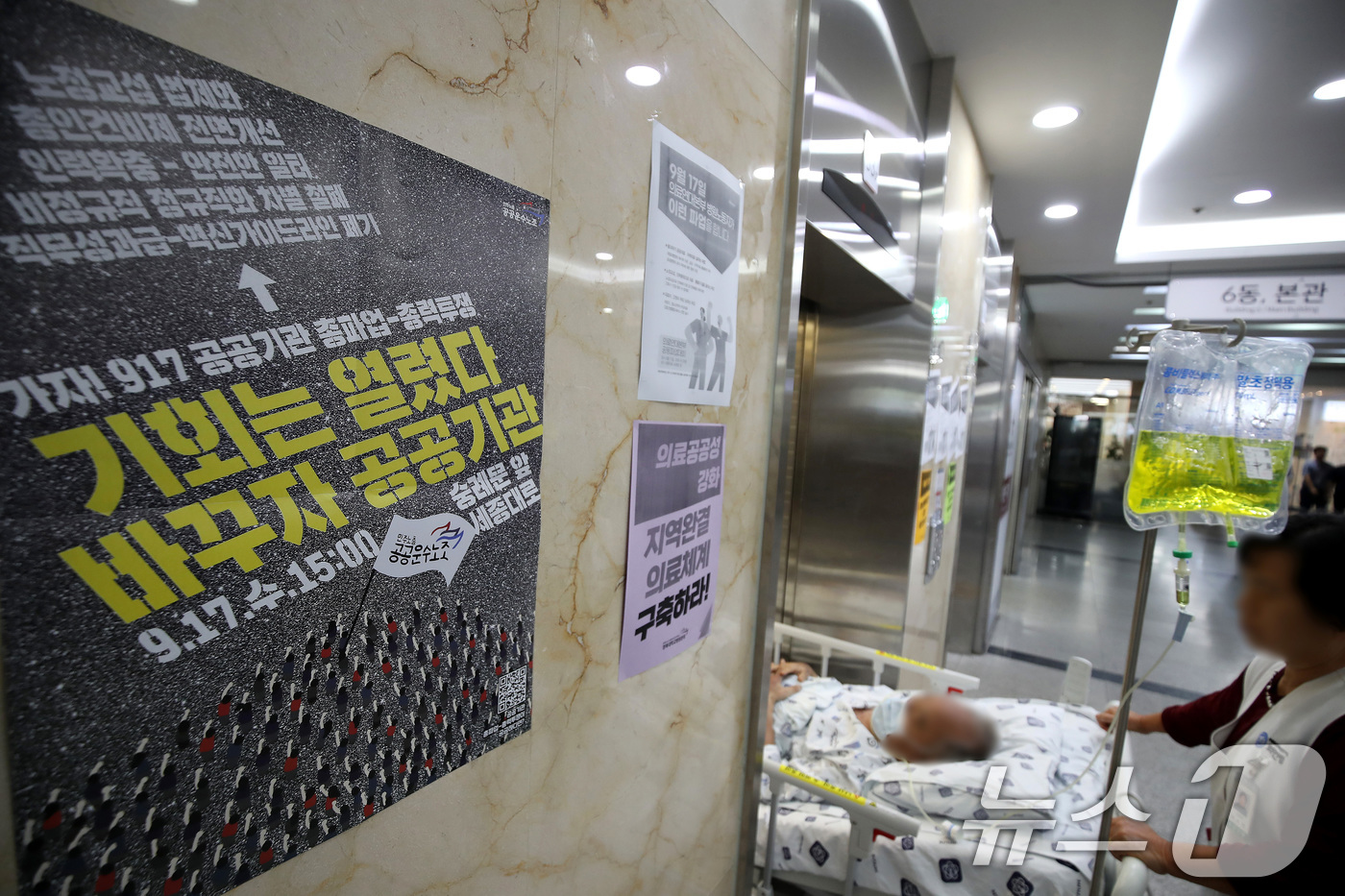 (대구=뉴스1) 공정식 기자 = 경북대학교병원 노조가 서울대·강원대·충북대병원 노조와 함께 공동 파업에 돌입한 17일 대구 중구 경북대병원에서 간병인이 환자 병상을 밀며 승강기에 …