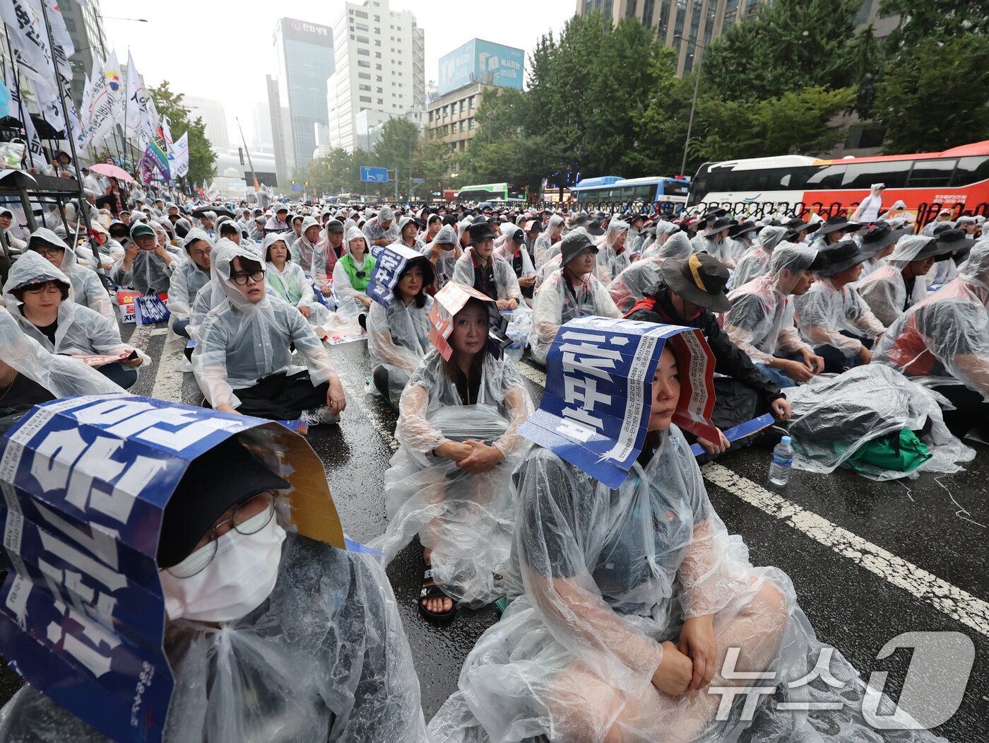 본문 이미지 - 민주노총 공공운수노조 조합원들이 17일 오후 서울 세종대로 숭례문앞에서 손팻말로 비를 가리며 &#39;공공기관 노동자 총파업 총력투쟁대회&#39;를 진행하고 있다. 2025.9.17/뉴스1 ⓒ News1 황기선 기자