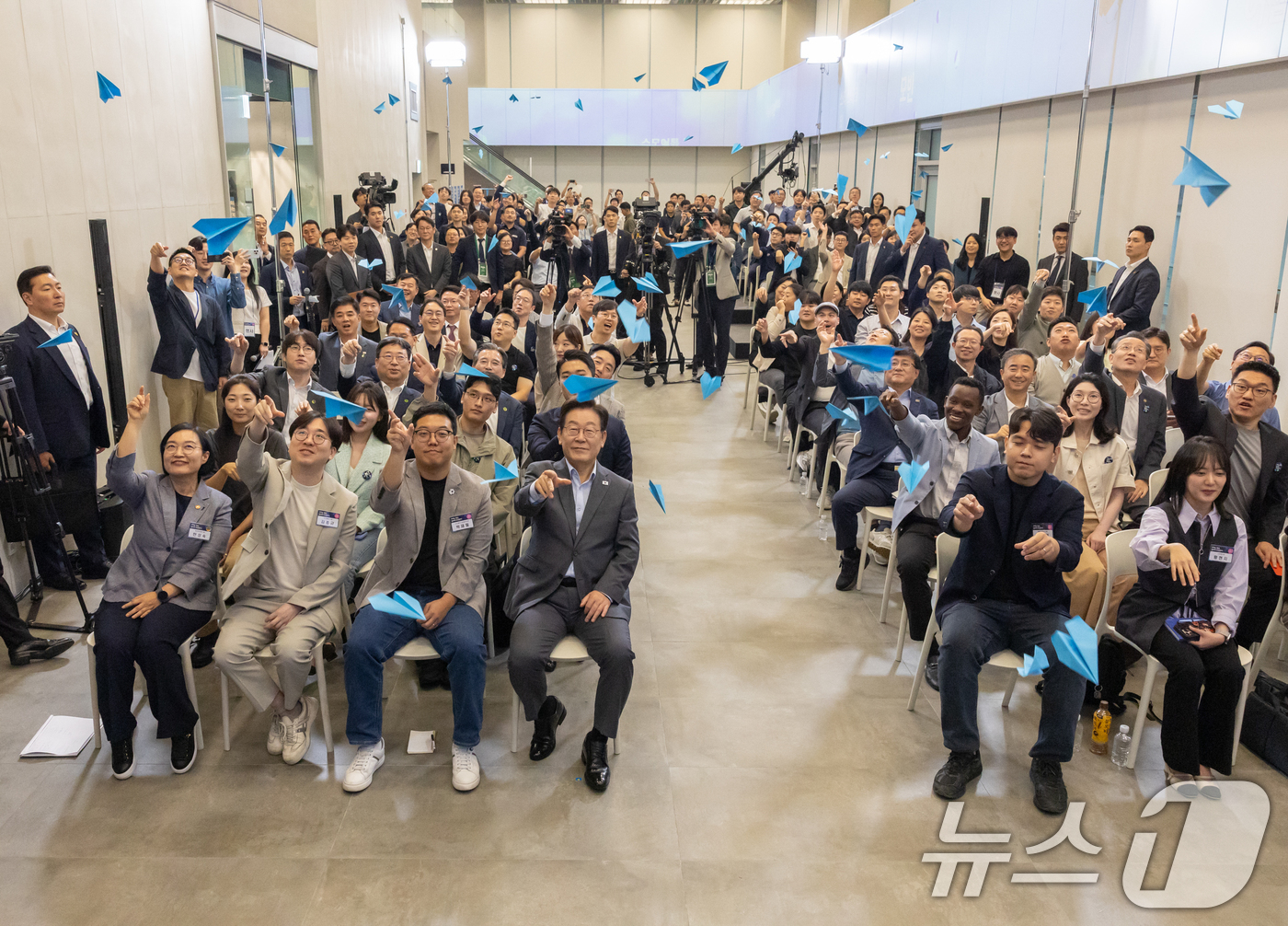 (서울=뉴스1) 허경 기자 = 이재명 대통령이 17일 경기도 성남시 스타트업 스퀘어에서 열린 청년 스타트업 상상콘서트에서 참석자들과 종이비행기를 날리고 있다. (대통령실 제공. 재 …