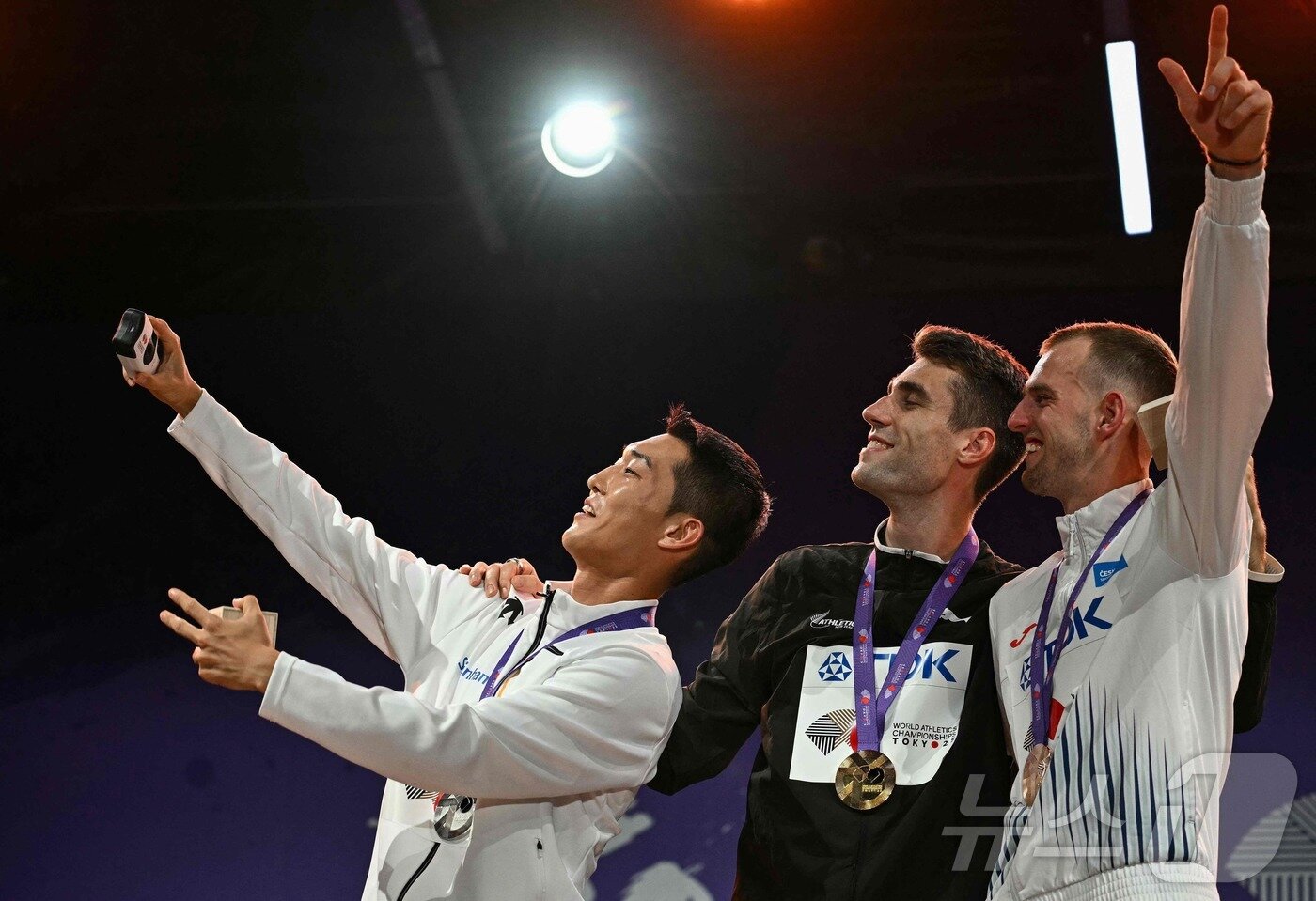 본문 이미지 - 지난 17일 열린 세계선수권 남자 높이뛰기 시상식에서 우상혁과 해미시 커, 얀 슈테펠라&#40;왼쪽부터&#41;가 사진을 찍고 있다. ⓒ AFP=뉴스1