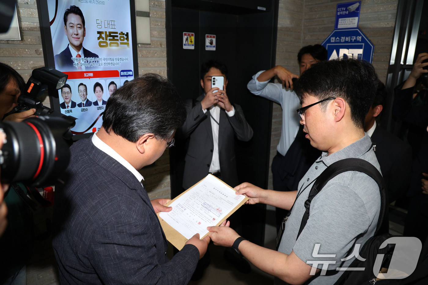 (서울=뉴스1) 신웅수 기자 = 국민의힘 당원명부 압수수색에 나선 김건희특검 수사관들이 18일 서울 여의도 중앙당사에서 국민의힘 변호사에게 영장을 제시하고 있다. 2025.9.18 …