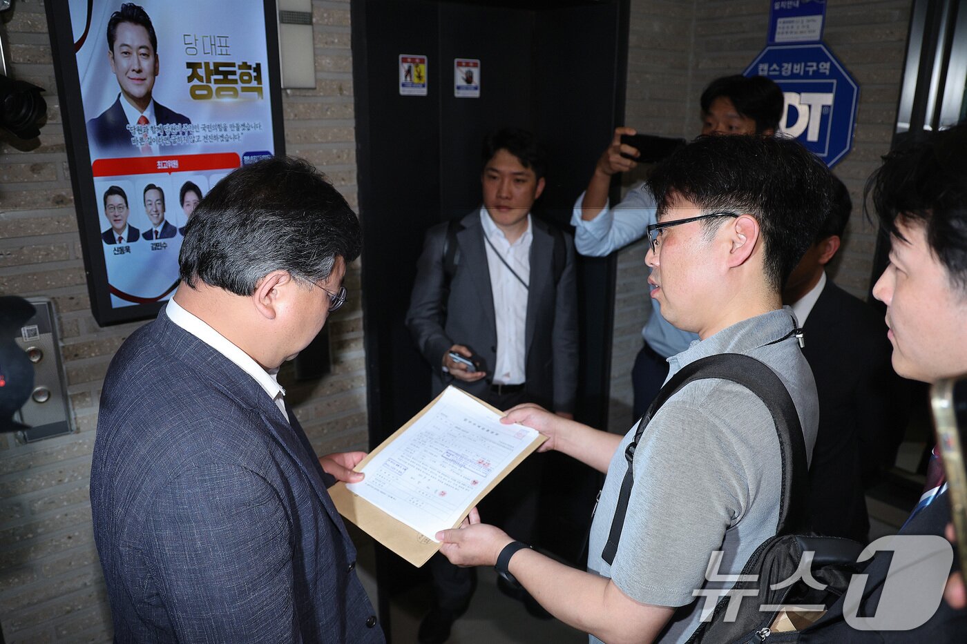 본문 이미지 - 국민의힘 당원명부 압수수색에 나선 김건희특검 수사관들이 18일 서울 여의도 중앙당사에서 국민의힘 변호사에게 영장을 제시하고 있다. 2025.9.18/뉴스1 ⓒ News1 신웅수 기자