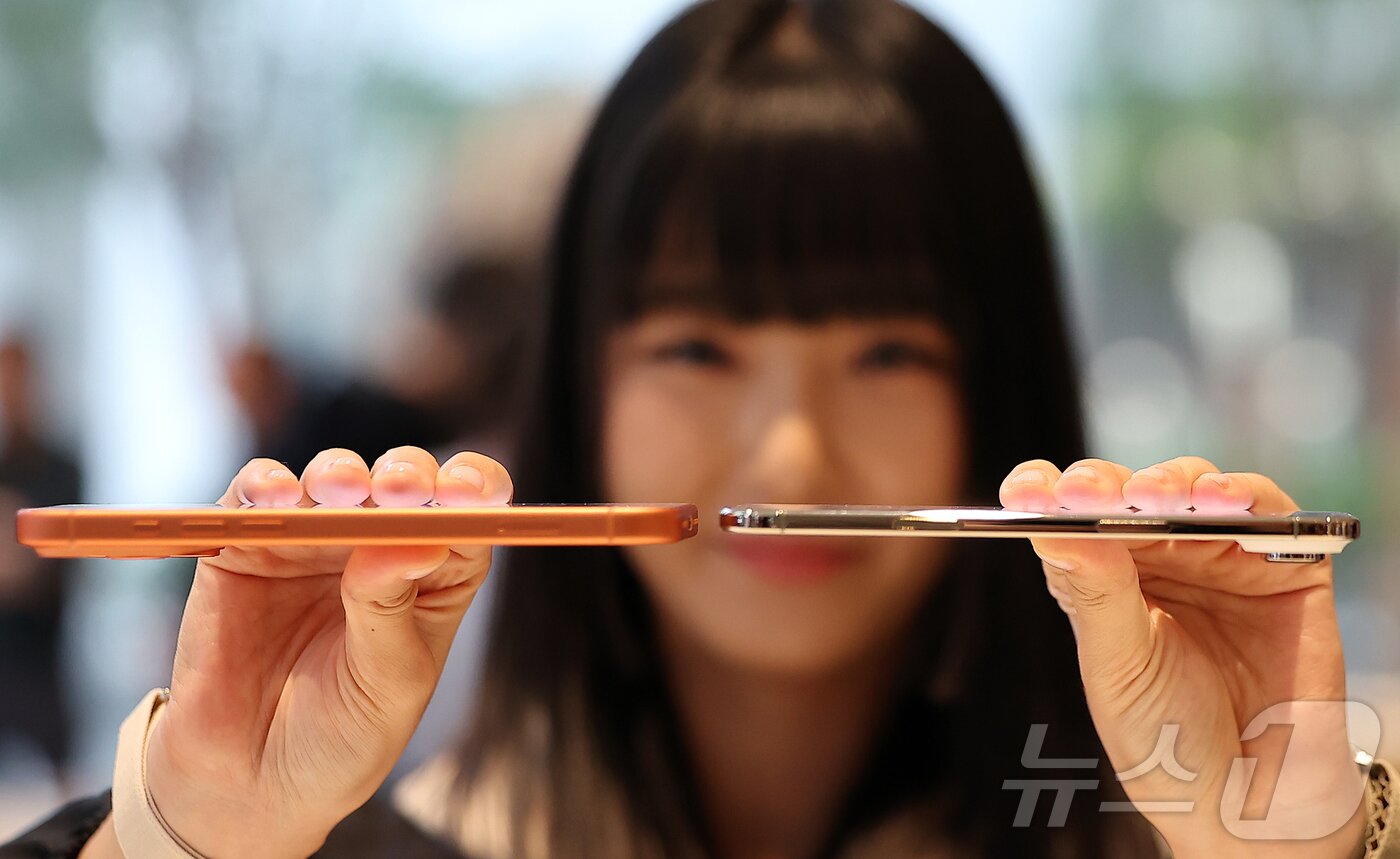 본문 이미지 - 19일 오전 서울 중구 명동 애플스토어에서 한 시민이 이날 출시된 애플의 스마트폰 &#39;아이폰 에어&#39;&#40;오른쪽&#41;와 &#39;아이폰17프로&#39;의 두께를 비교하고 있다. 2025.9.19/뉴스1 ⓒ News1 김진환 기자
