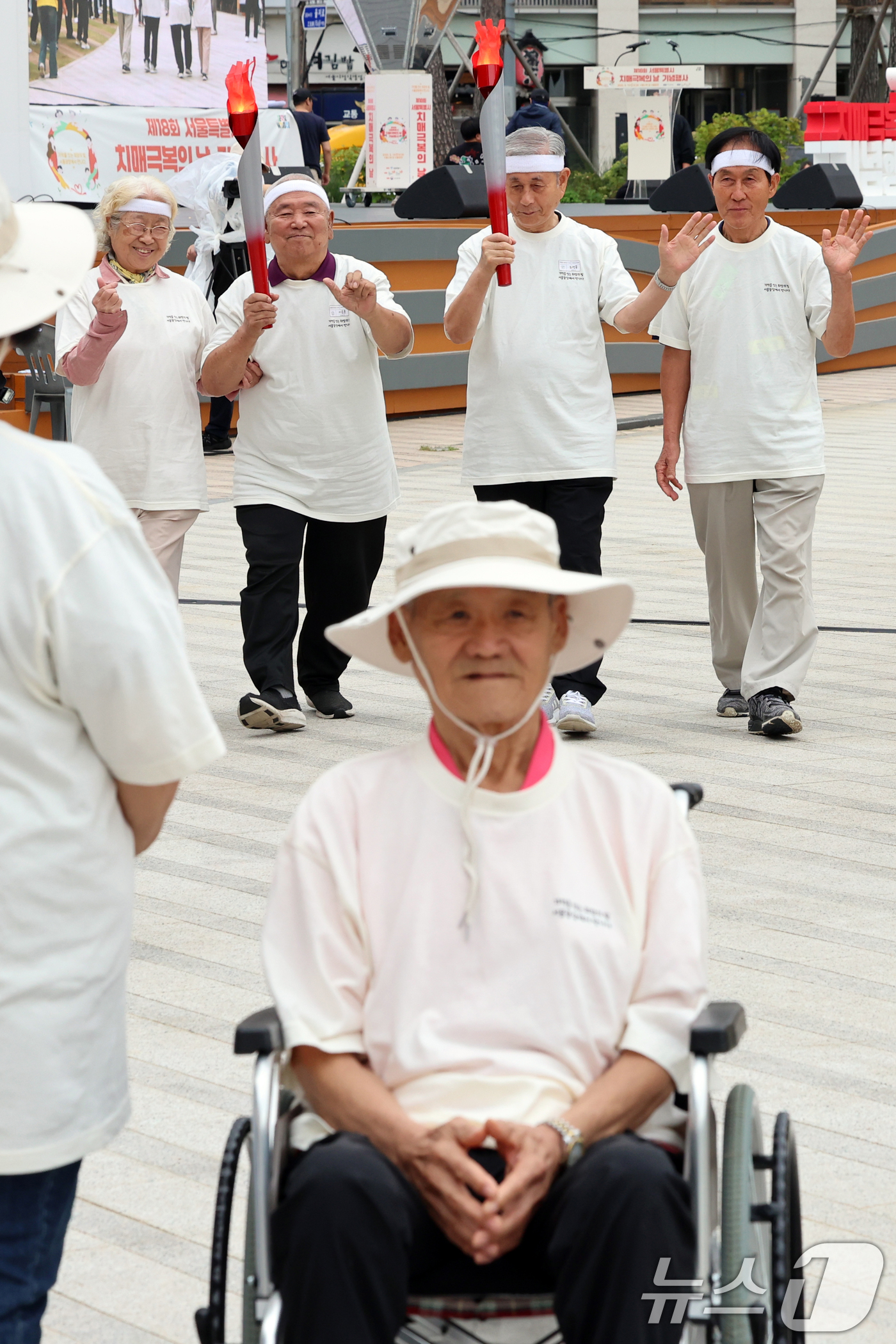 (서울=뉴스1) 황기선 기자 = 19일 오전 서울광장에서 열린 '제18회 치매극복의 날 기념행사'에서 참석자들이 성화 봉송 릴레이를 하고 있다.  2025.9.19/뉴스1