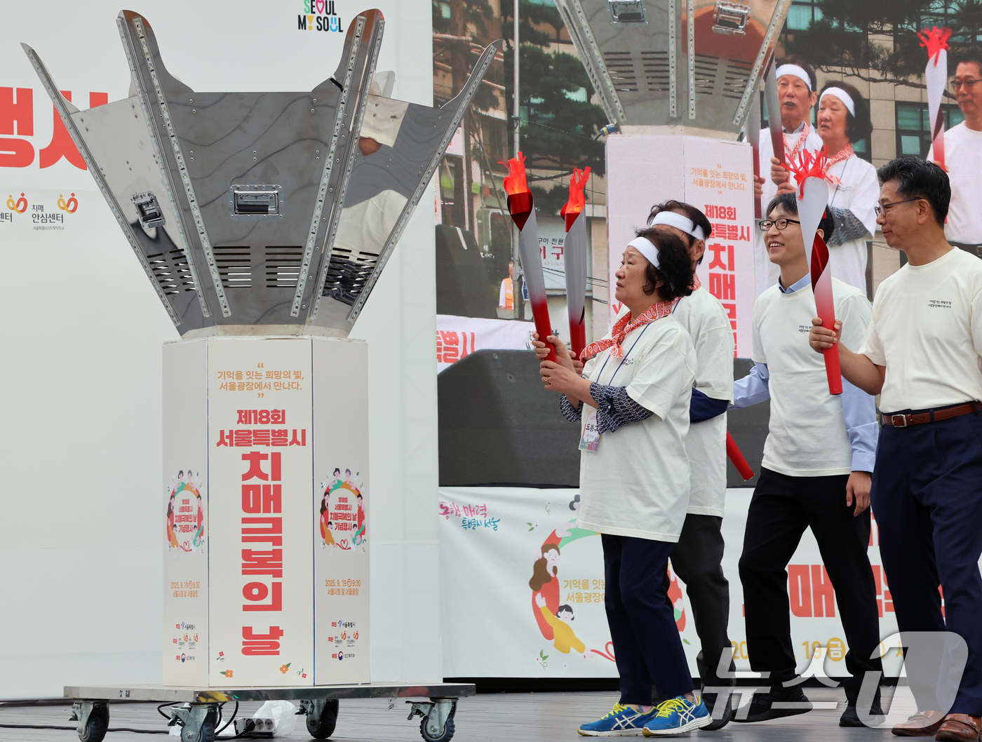 (서울=뉴스1) 황기선 기자 = 19일 오전 서울광장에서 열린 '제18회 치매극복의 날 기념행사'에서 참석자들이 성화 봉송 릴레이를 하고 있다.  2025.9.19/뉴스1