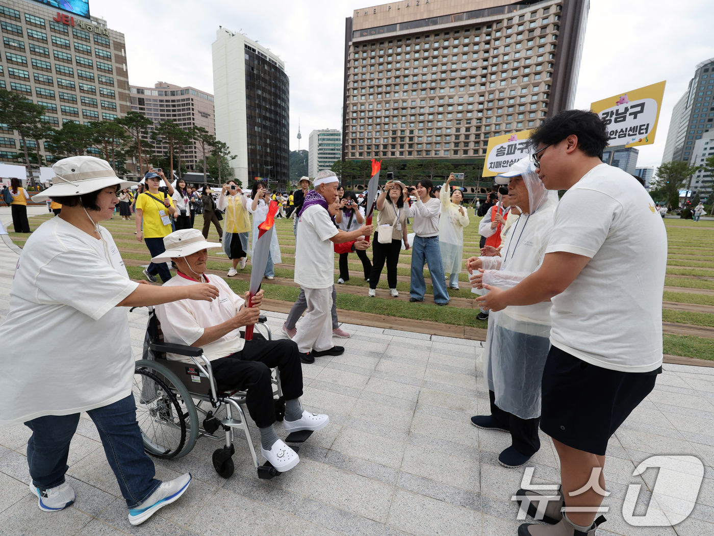 (서울=뉴스1) 황기선 기자 = 19일 오전 서울광장에서 열린 '제18회 치매극복의 날 기념행사'에서 참석자들이 성화 봉송 릴레이를 하고 있다.  2025.9.19/뉴스1