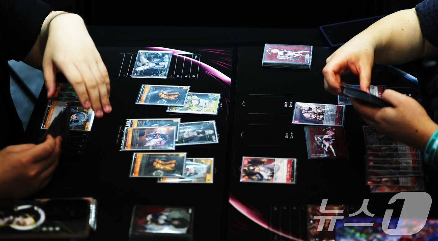 본문 이미지 - 19일 서울 중구 동대문디자인플라자&#40;DDP&#41;에서 열린 &#39;엔터테크 서울 2025&#39;에서 관람객이 카드 게임을 하고 있다. 2025.9.19/뉴스1 ⓒ News1 황기선 기자