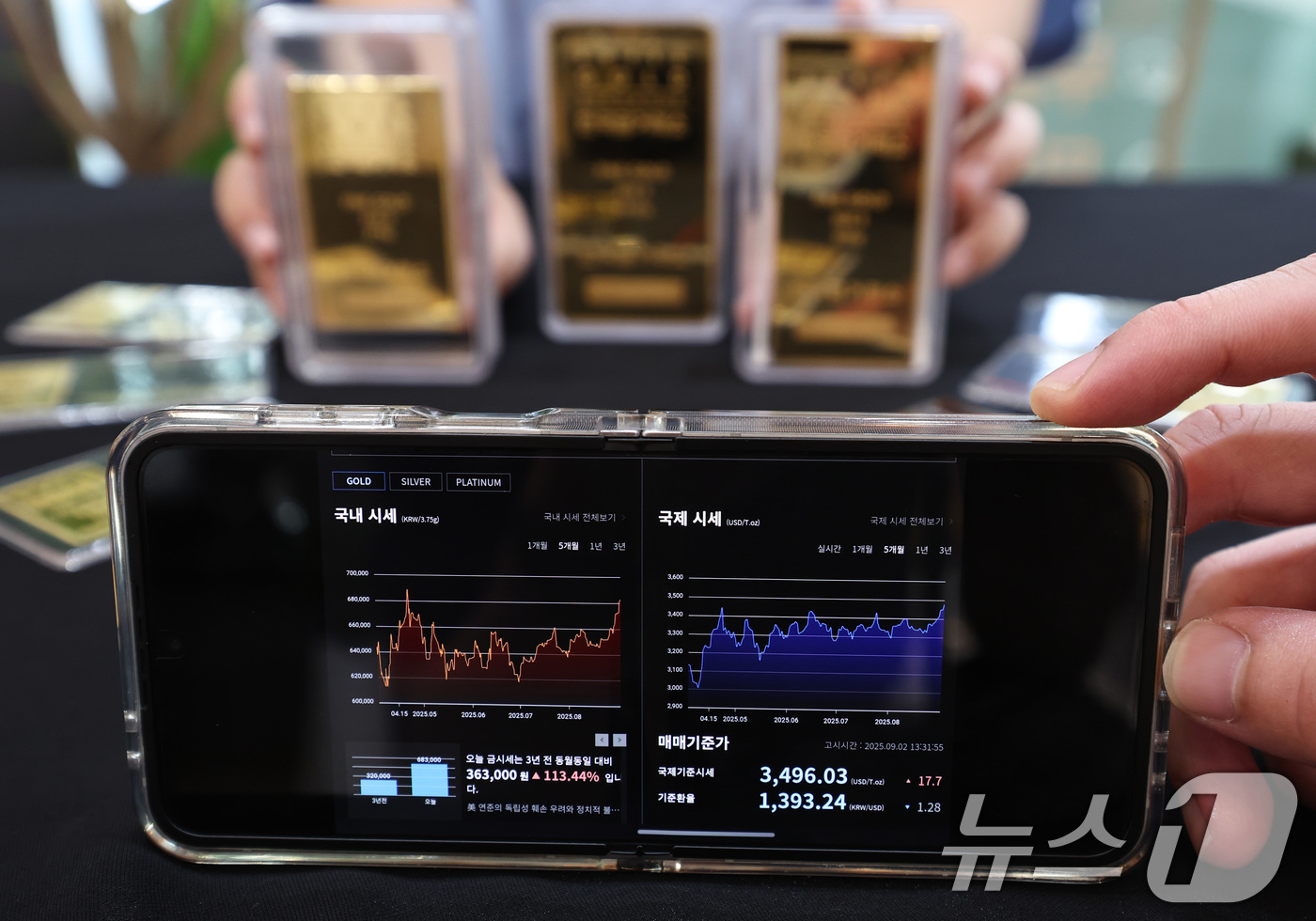 (서울=뉴스1) 구윤성 기자 = 금과 은 가격이 급등세를 보이는 2일 서울 종로구 한국금거래소에서 관계자가 골드바를 내보이고 있다.1일(현지시간) 런던 거래에서 금 선물 가격은 온 …