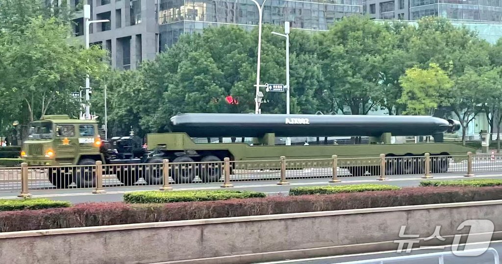 본문 이미지 -  중국의 항일전쟁 및 세계 반파시스트 전쟁&#40;제2차 세계대전&#41; 승리 80주년&#40;전승절&#41;을 앞두고 중국 초대형 무인잠수정&#40;XLUUV&#41; &#39;AJX-002&#39;가 예행 연습을 위해 중국군 전용 군용 트럭에 실려 도시 도로를 이동 중인 모습. &#40;웨이보 갈무리&#41;