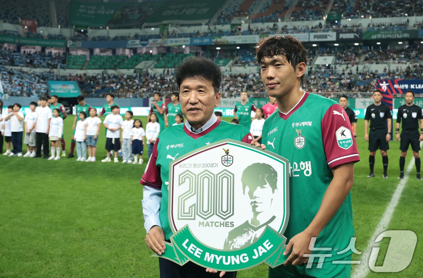 본문 이미지 - 대전하나시티즌 이명재(오른쪽)가 20일 오후 대전월드컵경기장에서 열린 K리그 통산 200회 출전 기념식에서 함영주 하나금융그룹 회장과 기념 촬영을 하고 있다. 2025.9.20/뉴스1 ⓒ News1 권현진 기자