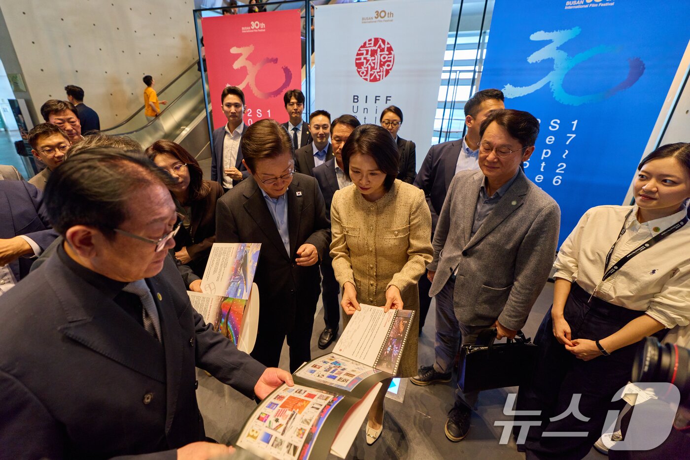 본문 이미지 - 이재명 대통령과 김혜경 여사가 20일 부산 해운대구 영화의 전당에서 부산국제영화제 공식상영작 '극장의 시간들' 관람에 앞서 기념우표 설명을 듣고 있다. (대통령실 제공. 재판매 및 DB 금지) 2025.9.20/뉴스1 ⓒ News1 허경 기자