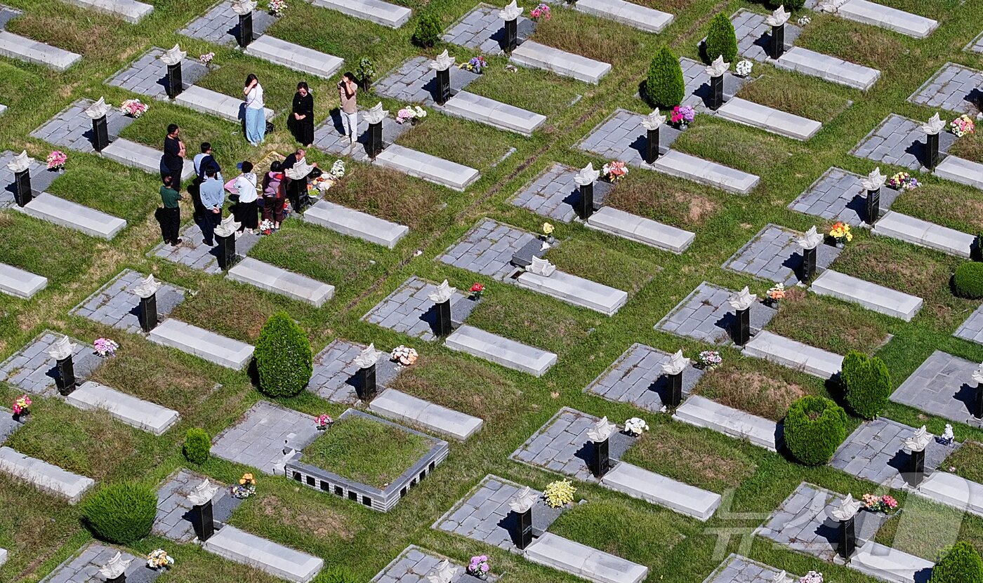 본문 이미지 - 추석 명절을 2주가량 앞둔 21일 인천 부평구 인천가족공원에서 한 가족이 이른 성묘를 하고 있다. 2025.9.21/뉴스1 ⓒ News1 김도우 기자