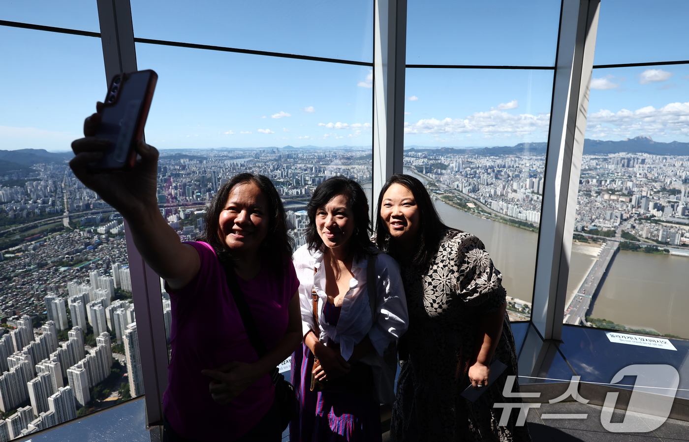 (서울=뉴스1) 김민지 기자 = 완연한 가을 날씨를 보인 21일 서울 송파구 롯데월드 서울스카이 전망대에서 관광객들이 맑은 하늘을 배경으로 사진을 찍고 있다. 2025.9.21/뉴 …