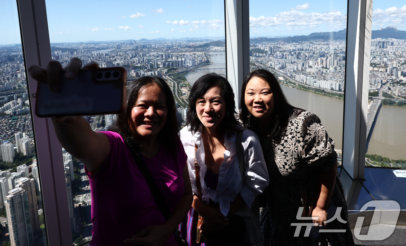 (서울=뉴스1) 김민지 기자 = 완연한 가을 날씨를 보인 21일 서울 송파구 롯데월드 서울스카이 전망대에서 관광객들이 맑은 하늘을 배경으로 사진을 찍고 있다. 2025.9.21/뉴 …