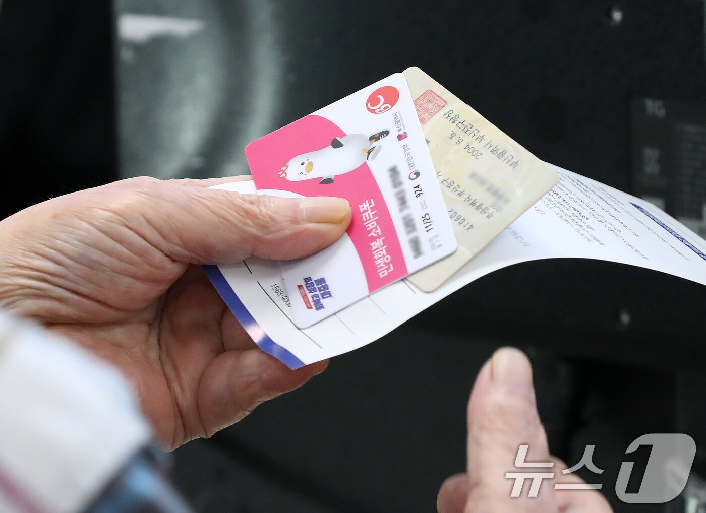 본문 이미지 - 2차 민생회복 소비쿠폰 신청 첫날인 22일 부산 부산진구 가야2동주민센터에서 시민들이 한 시민이 소비쿠폰을 받고 있다. 2025.9.22/뉴스1 ⓒ News1 윤일지 기자