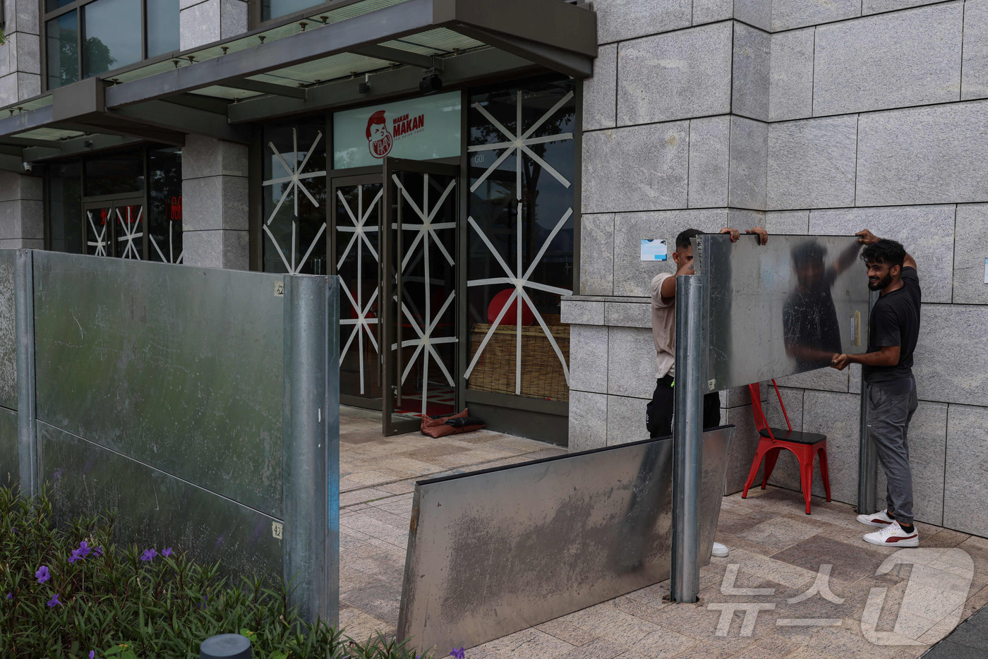 (홍콩 로이터=뉴스1) 권준언 기자 = 23일(현지시간) 홍콩에서 태풍 라가사로 인한 홍수를 막기 위해 작업자들이 방수 강철판을 설치하고 있다. 2025.09.23.ⓒ 로이터=뉴스 …