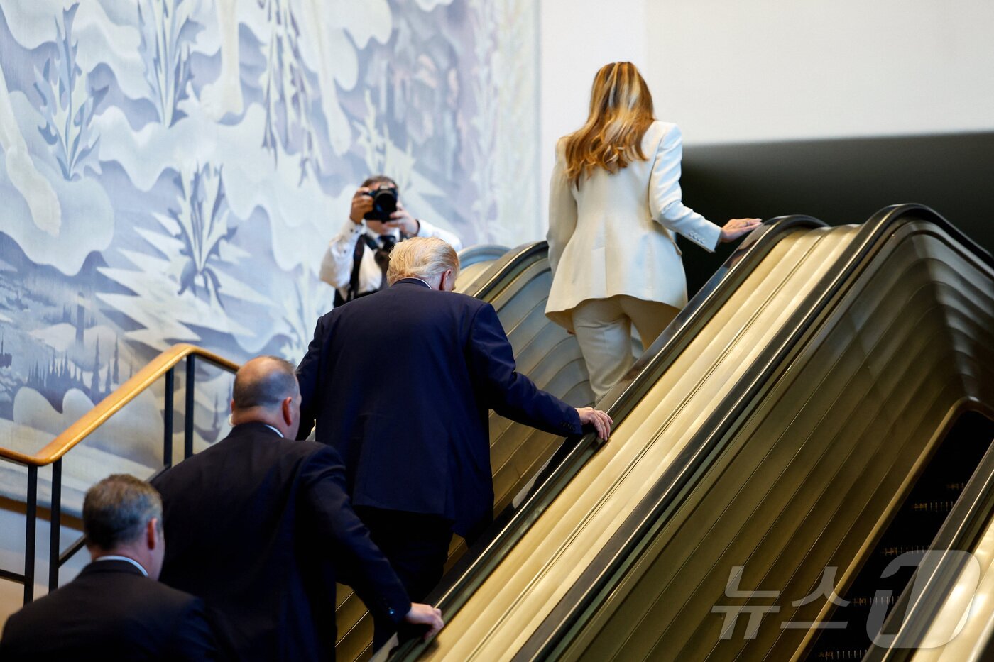 본문 이미지 - 도널드 트럼프 미국 대통령과 영부인 멜라니아 여사가 23일&#40;현지시간&#41; 미국 뉴욕 유엔 본부에서 열린 제80차 유엔 총회에 참석하기 위해 멈춰 선 에스컬레이터를 걸어 오르고 있다. 2025.09.23. ⓒ 로이터=뉴스1 ⓒ News1 류정민 특파원