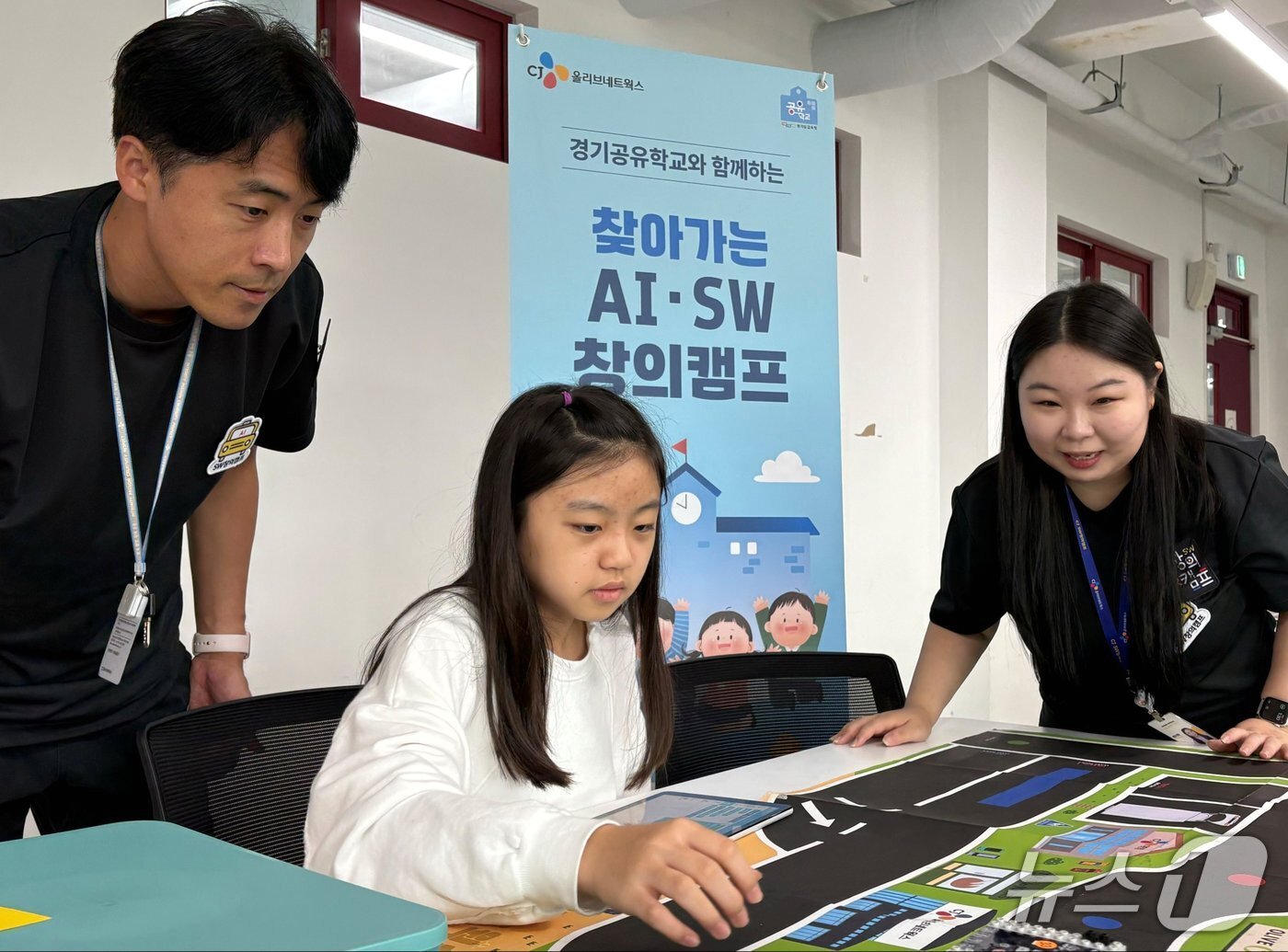 본문 이미지 - 참가학생이 CJ올리브네트웍스 임직원 강사들과 코딩한 자율주행 모형차의 이동경로를 확인하고 있다.&#40;CJ올리브네트웍스 제공&#41;
