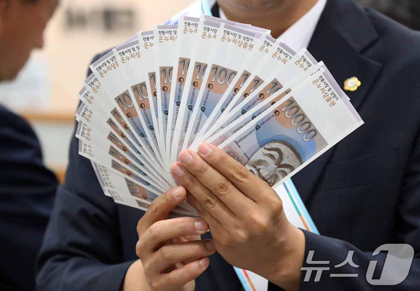 본문 이미지 - 대구에서 열린 &#39;추석맞이 전통시장 온누리상품권 구매 행사&#39;에서 중구 관계자들이 전통시장 활성화를 위해 구매한 상품권을 펼쳐 보이고 있다. 2025.9.24/뉴스1 ⓒ News1 공정식 기자