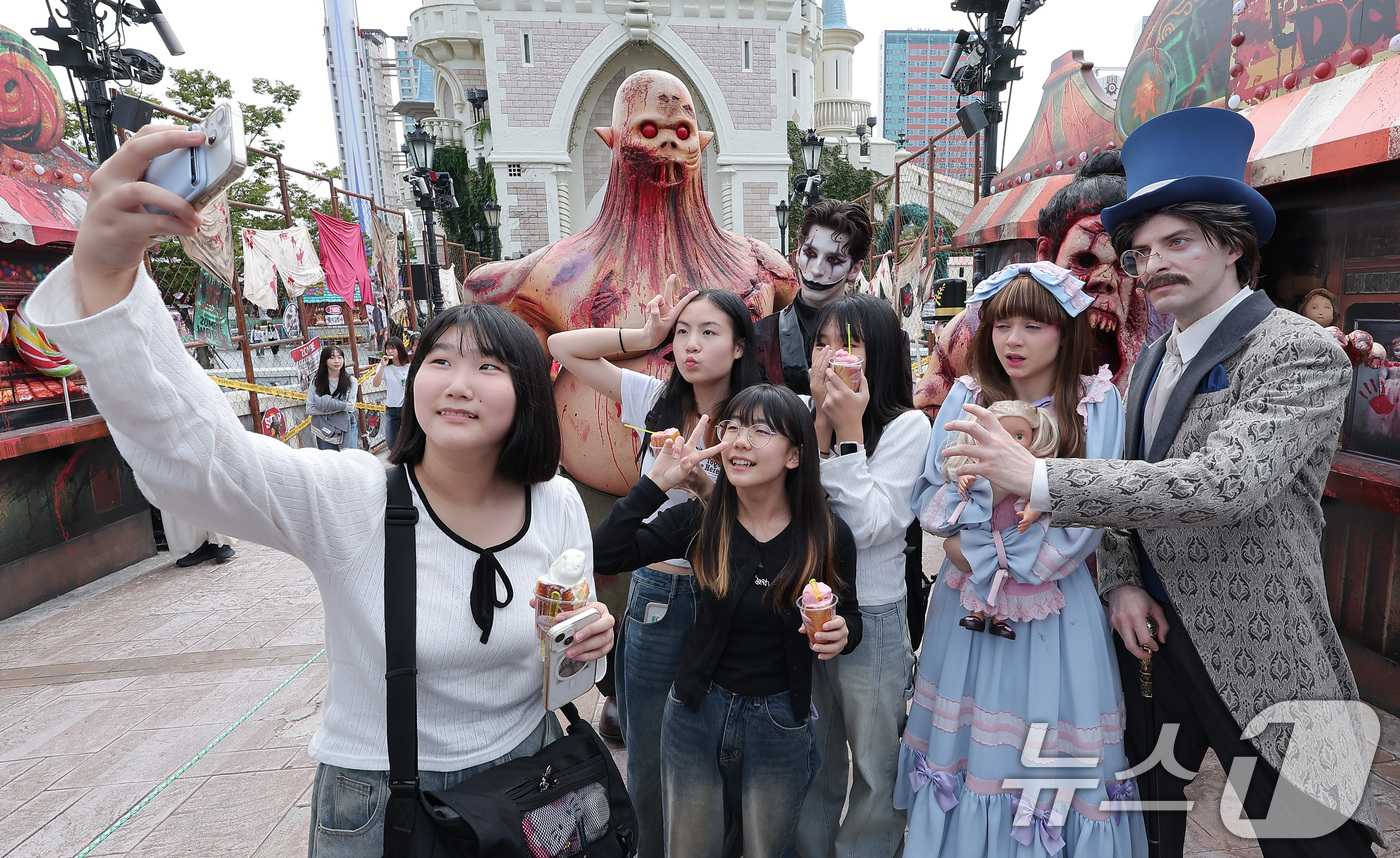(서울=뉴스1) 김성진 기자 = 25일 서울 송파구 롯데월드 어드벤처 매직아일랜드에서 열린 호러 판타지 가을 시즌 축제에서 학생들이 '더 마리오네트' 분장을 한 연기자들과 기념촬영 …