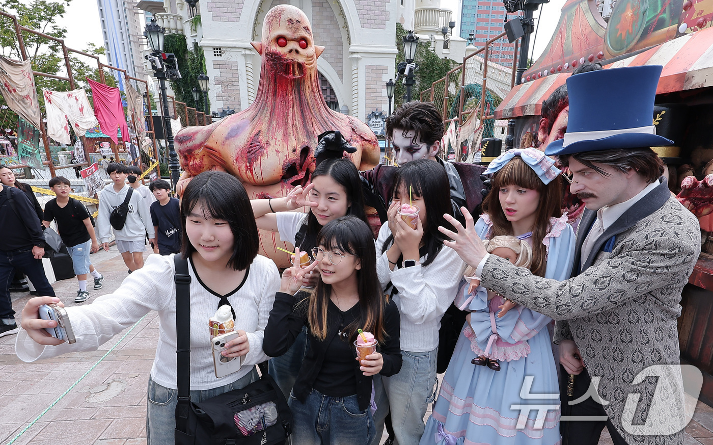 (서울=뉴스1) 김성진 기자 = 25일 서울 송파구 롯데월드 어드벤처 매직아일랜드에서 열린 호러 판타지 가을 시즌 축제에서 학생들이 '더 마리오네트' 분장을 한 연기자들과 기념촬영 …