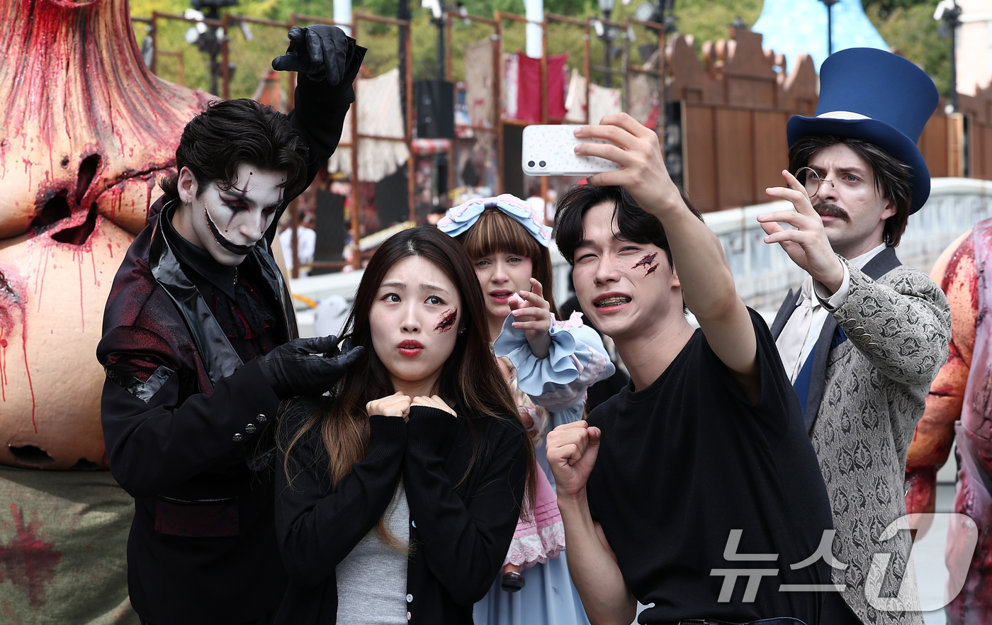 (서울=뉴스1) 김성진 기자 = 25일 서울 송파구 롯데월드 어드벤처 매직아일랜드에서 열린 호러 판타지 가을 시즌 축제에서 모델들이 '더 마리오네트' 분장을 한 연기자들과 기념촬영 …