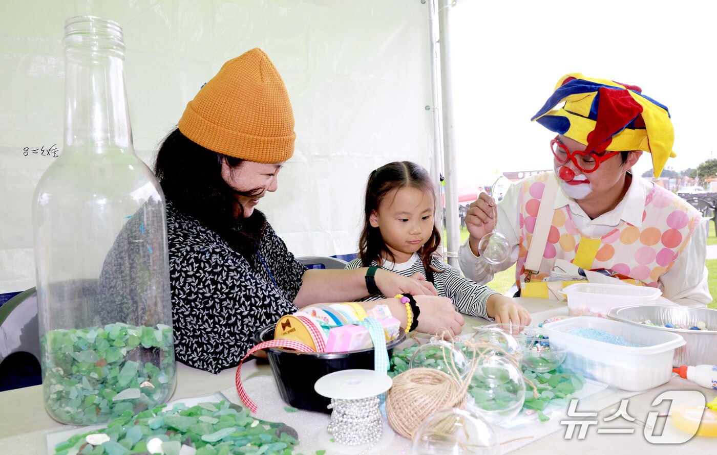 본문 이미지 - 박란이 공예작가(오른쪽)가 '무창포 신비의 바닷길' 축제에서 씨글라스 체험행사를 진행하고 있는 모습.(보령시 제공. 재판매 및 DB금지)/뉴스1