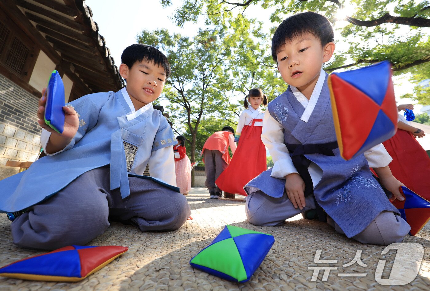 본문 이미지 - 26일 서울 종로구 운련궁에서 열린 ‘제3회 종로 전통생활문화한마당’을 찾은 명륜어린이집 아이들이 딱지치기를 하고 있다. 2025.9.26/뉴스1 ⓒ News1 이호윤 기자