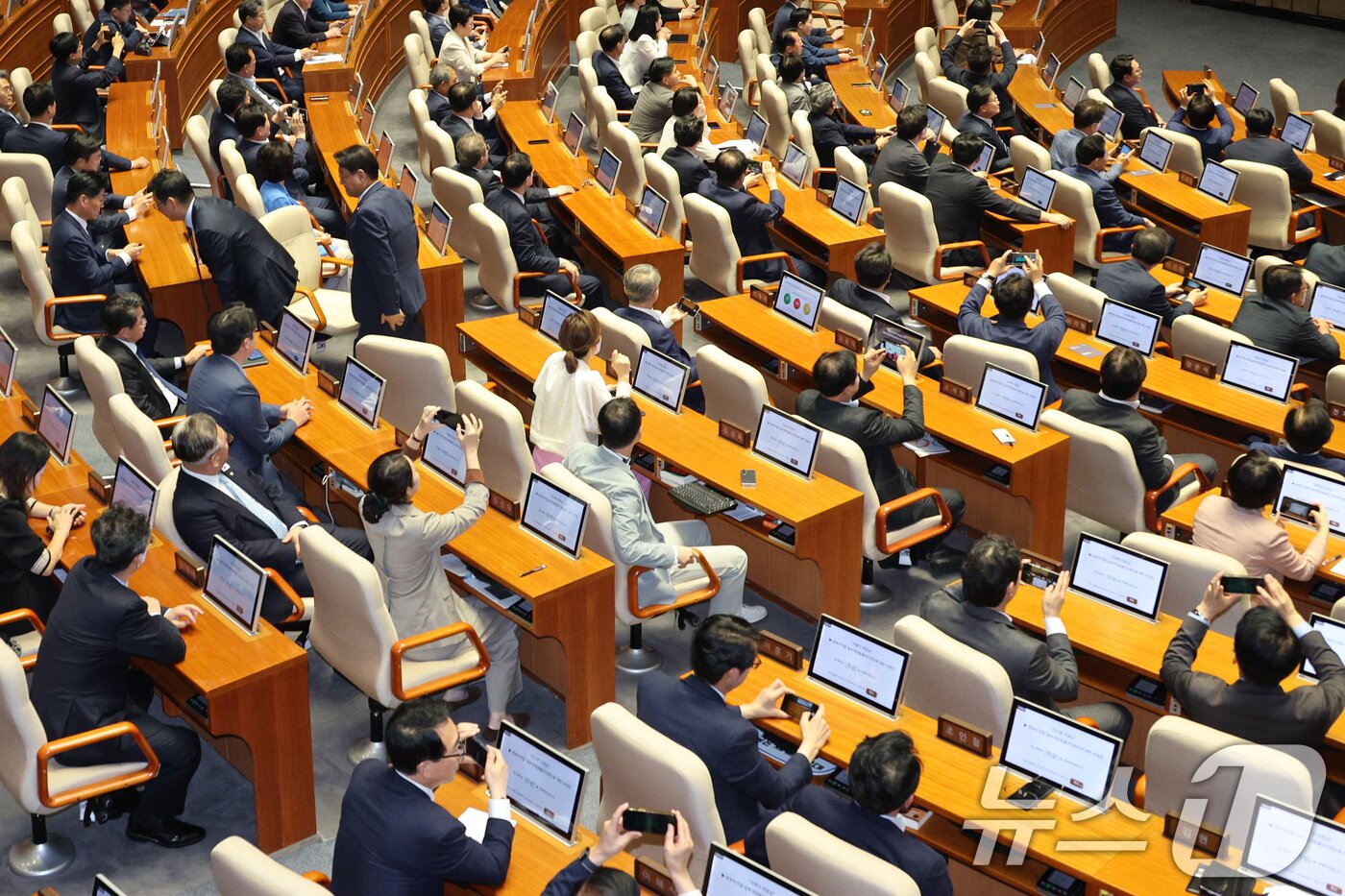 본문 이미지 - 26일 서울 여의도 국회에서 열린 제429회국회&#40;정기회&#41; 9차 본회의에서 검찰청 폐지를 골자로 한 정부조직법 개정안이 통과되자 의원들이 스마트폰으로 사진을 남기고 있다. 2025.9.26/뉴스1 ⓒ News1 신웅수 기자