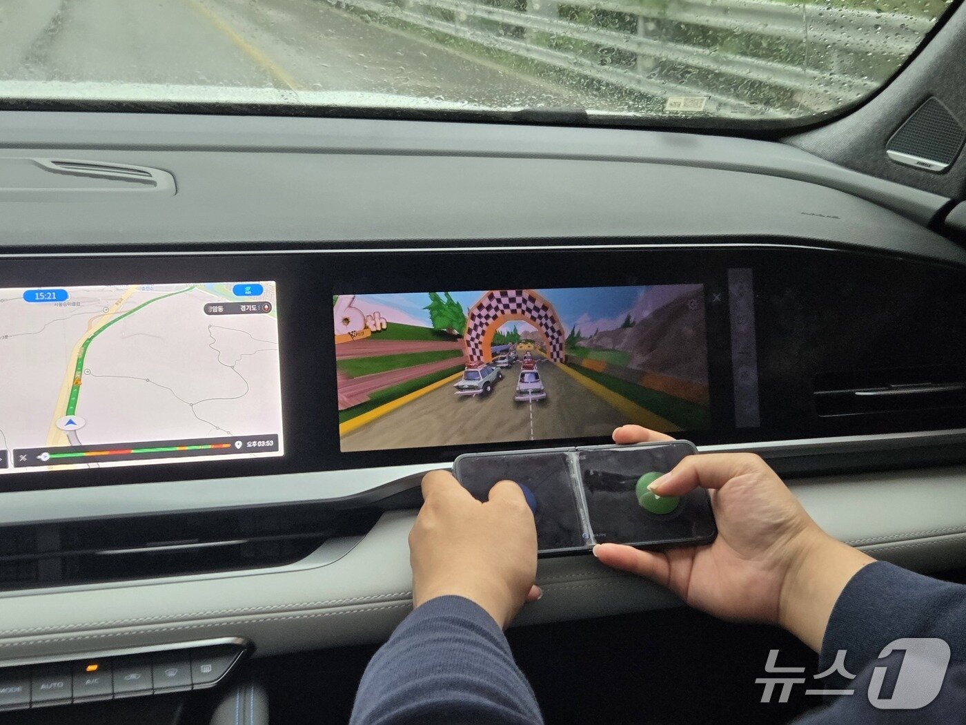 본문 이미지 - 4일 경기 포천에서 촬영한 르노코리아 중형 스포츠유틸리티차&#40;SUV&#41; &#39;그랑 콜레오스&#39; 2026년형 하이브리드 E-테크&#40;Tech&#41; 에스프리 알핀&#39; 트림 내부. 20여종의 게임이 처음으로 추가돼 동승석에서 레이싱 게임을 즐기는 모습이다. 연동된 스마트폰은 게임 조이스틱처럼 활용할 수 있다. 2025.09.24/뉴스1 김성식