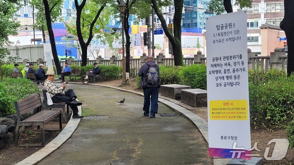 본문 이미지 - 25일 서울 종로구 탑골공원 내에서 노인들이 벤치에 앉아 시간을 보내고 있다. 탑골공원에서는 &#39;바둑, 장기 등 오락행위, 흡연, 음주가무, 상거래 행위 등은 모두 금지된다&#39;는 내용의 안내문이 곳곳에 배치돼 있었다.