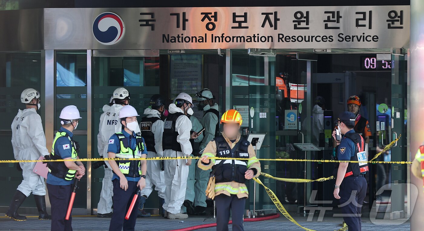 본문 이미지 - 27일 오전 대전 유성구 국가정보자원관리원 화재현장에서 경찰 과학수사대 화재감식 관계자들이 건물 내부로 이동하고 있다. 전산 자원을 통합 관리하는 행정안전부 산하 국가정보자원관리원에서 지난 26일 오후 배터리 교체 작업 중 화재가 발생, 정부 온라인 서비스 70개가 마비됐다. 2025.9.27/뉴스1 ⓒ News1 김진환 기자