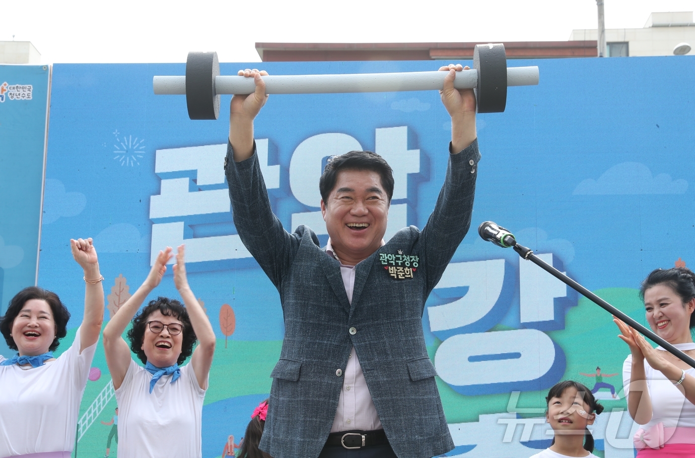 (서울=뉴스1) = 박준희 관악구청장이 27일 서울시 관악구 신림동 별빛내린천 일대에서 열린 ‘관악건강축제’에서 아령을 들어올리며 주민들과 함께 슬로건을 제창하는 건강 퍼포먼스를 …