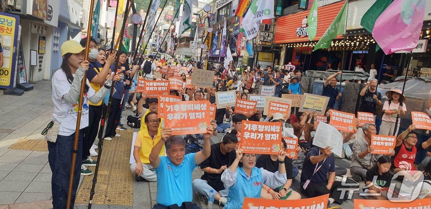 본문 이미지 - 27일 오후 부산 서면 하트조형물에서 열린 기후정의행진 집회에서 참가자가 피켓을 들고 구호를 외치고 있다. 2025.9.27/뉴스1 ⓒ News1 김태형 기자