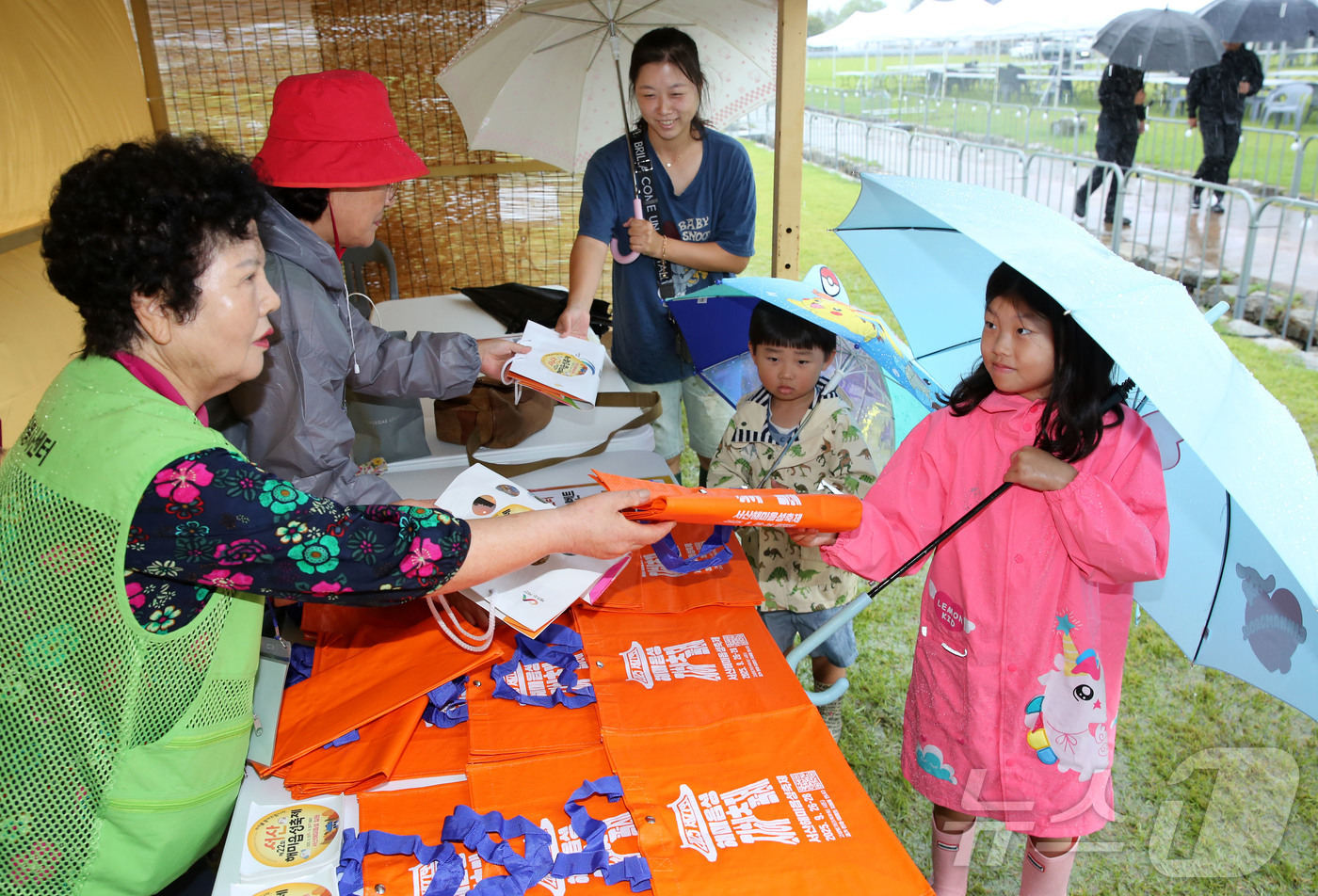 (서산=뉴스1) 김기태 기자 = 28일 서산해미읍성축제 한 부스에서 한 가족이 종이 가방을 타포린백으로 교환하는 이벤트에 참여하고 있다. (서산문화재단 제공. 재판매 및 DB금지) …