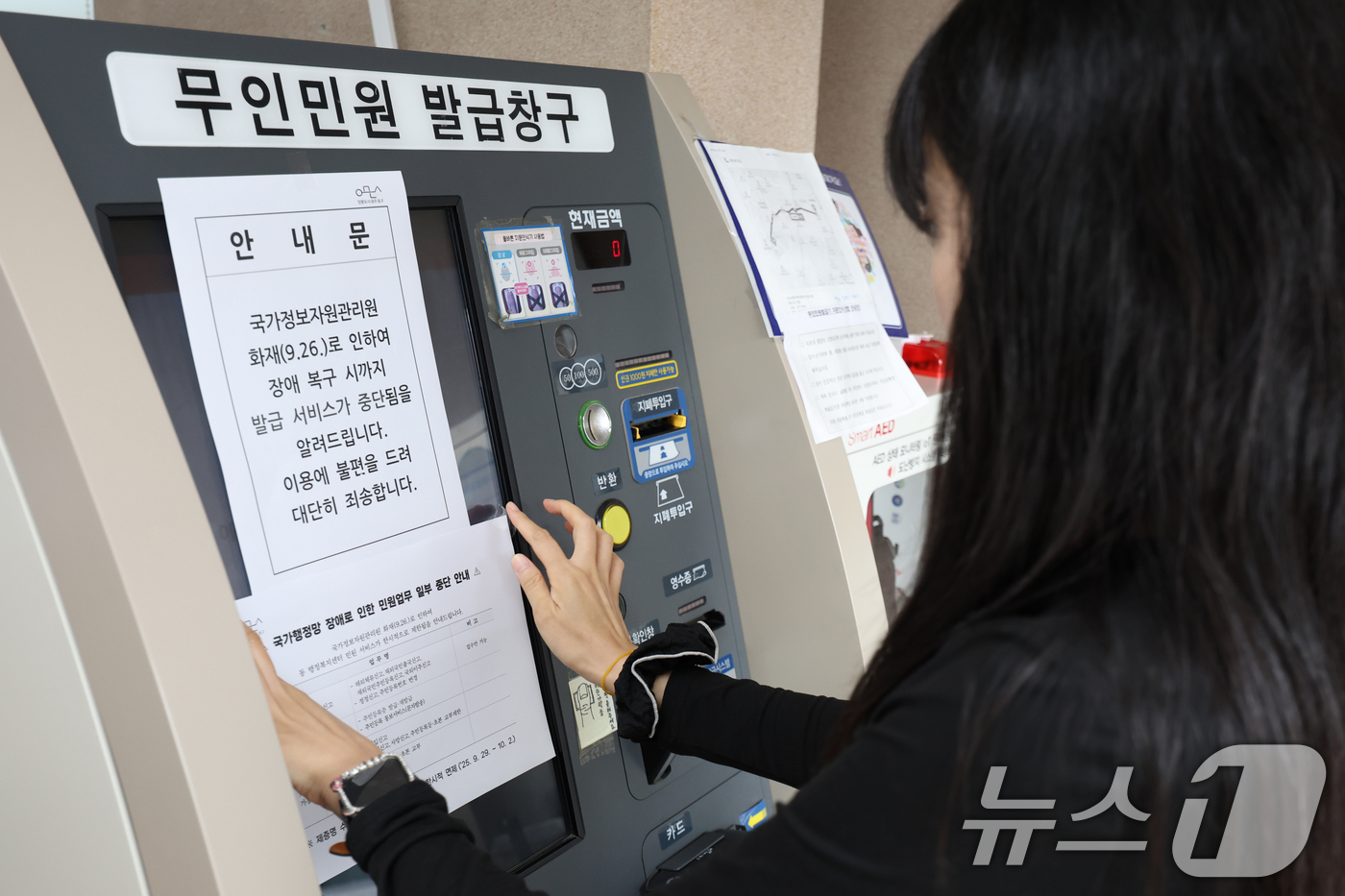 (광주=뉴스1) 이승현 기자 = 29일 오전 광주 동구 지산1동 행정복지센터에서 한 공무원이 무인민원발급창구에 국가정보자원관리원 화재 여파로 인한 민원 업무 일부 중단 안내문을 붙 …