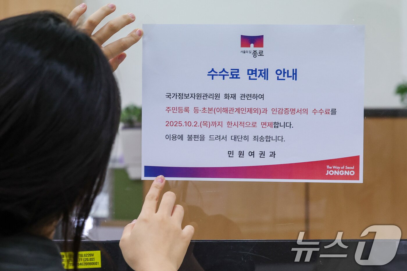 본문 이미지 - 정부가 대전 국가정보자원관리원&#40;국정자원&#41; 전산실에서 발생한 화재로 중단된 행정정보시스템 복구에 총력을 기울이고 있는 29일 오전 서울 종로구청에서 직원이 주민등록 등·초본과 인감증명서 수수료 한시적 면제 안내문을 부착하고 있다. 2025.9.29/뉴스1 ⓒ News1 안은나 기자