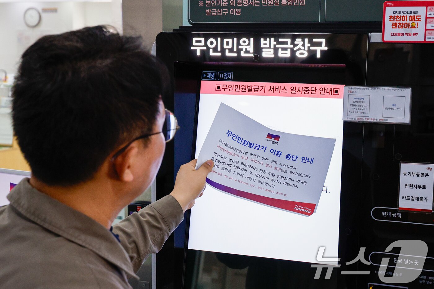 본문 이미지 - 정부가 대전 국가정보자원관리원&#40;국정자원&#41; 전산실에서 발생한 화재로 중단된 행정정보시스템 복구에 총력을 기울이고 있는 29일 오전 서울 종로구청에서 이용이 중단됐던 무인민원발급기가 복구돼 직원이 안내문을 뗴어내고 있다. 2025.9.29/뉴스1 ⓒ News1 안은나 기자