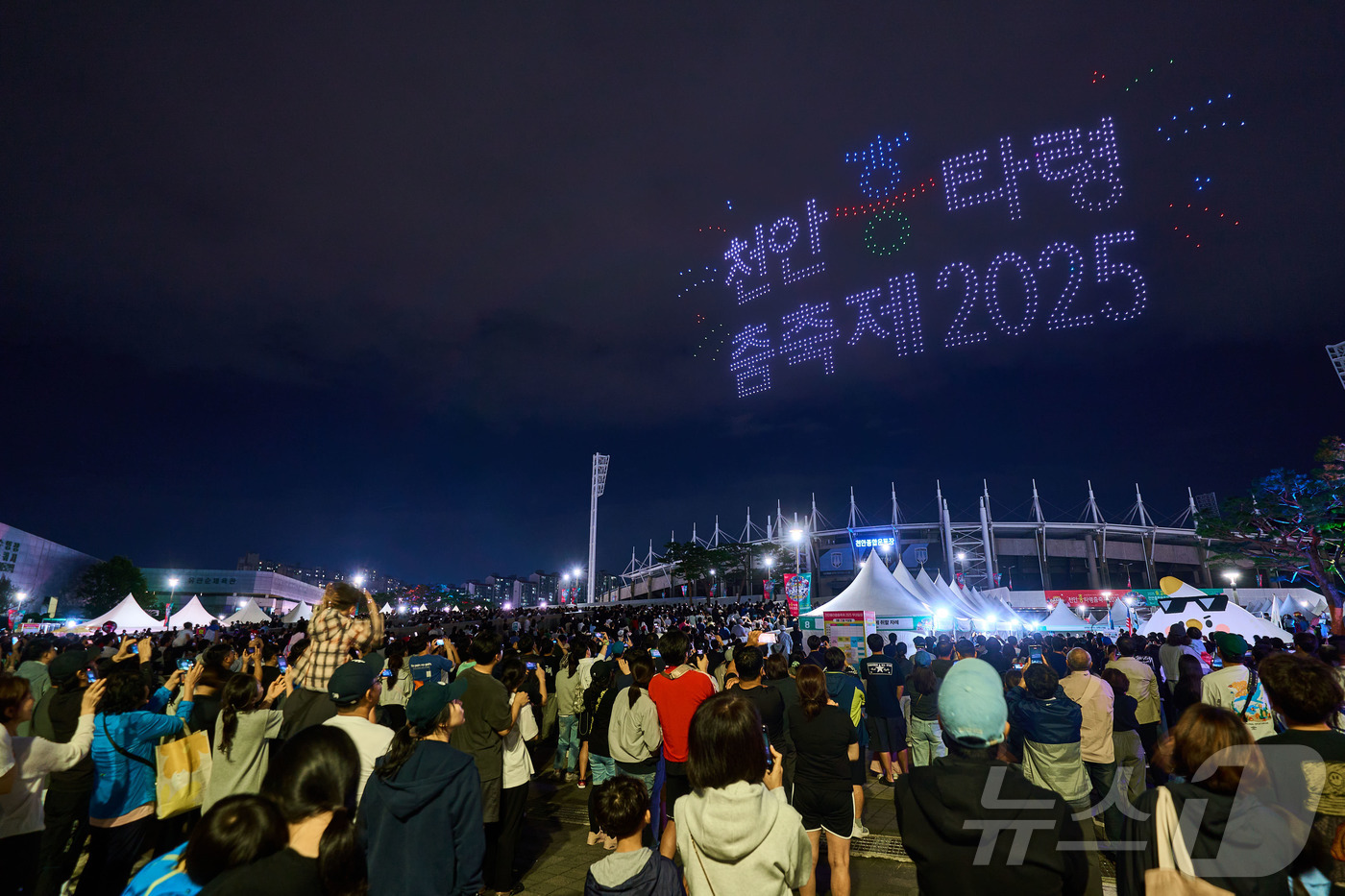 (천안=뉴스1) 이시우 기자 = 지난 28일 천안종합운동장에서 열린 '천안흥타령춤축제2025' 폐막식에서 시민들이 드론 라이트 쇼를 감상하고 있다. (천안시청 제공. 재판매 및 D …