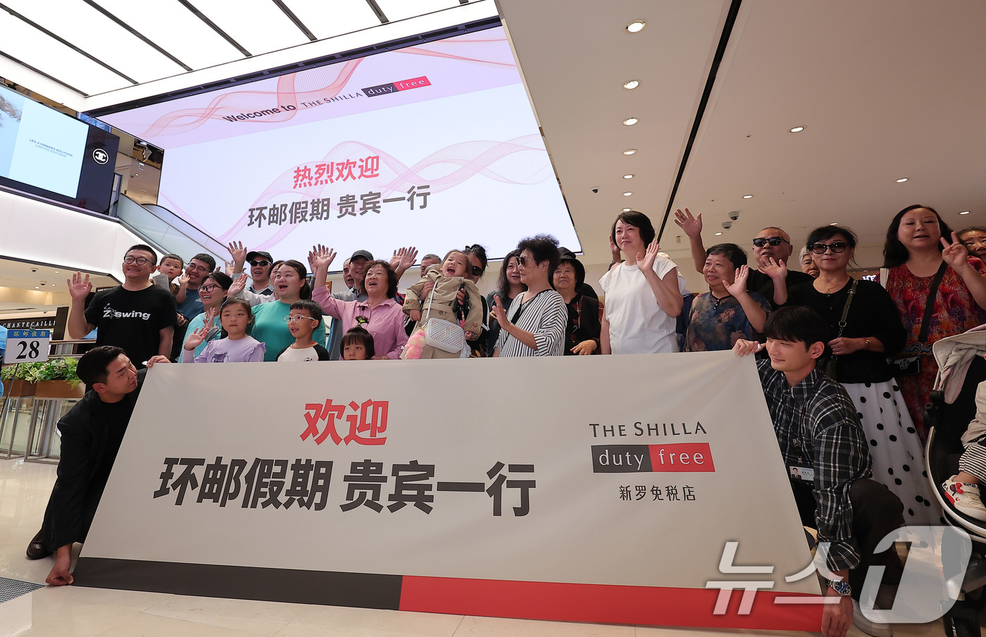 (서울=뉴스1) 김성진 기자 = 중국 단체관광객의 무비자 입국이 시작된 29일 서울 중구 신라면세점 서울점에서 중국인 관광객들이 면세점 측에서 마련한 환영 행사를 즐기고 있다.정부 …